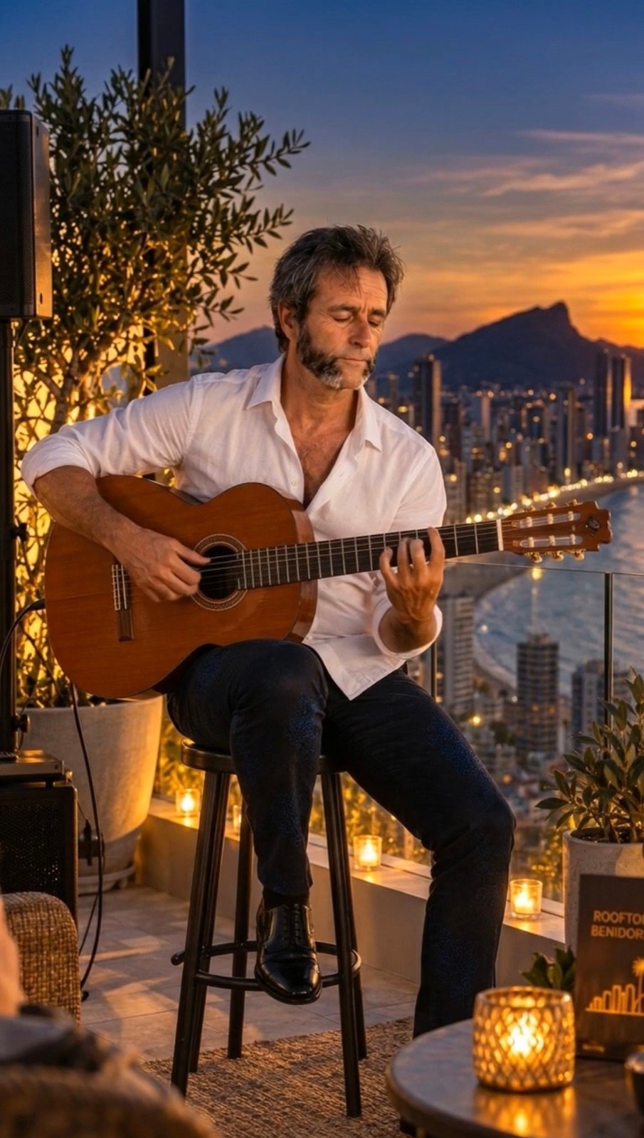 Kike sentado en un taburete tocando en una azotea de Benidorm
